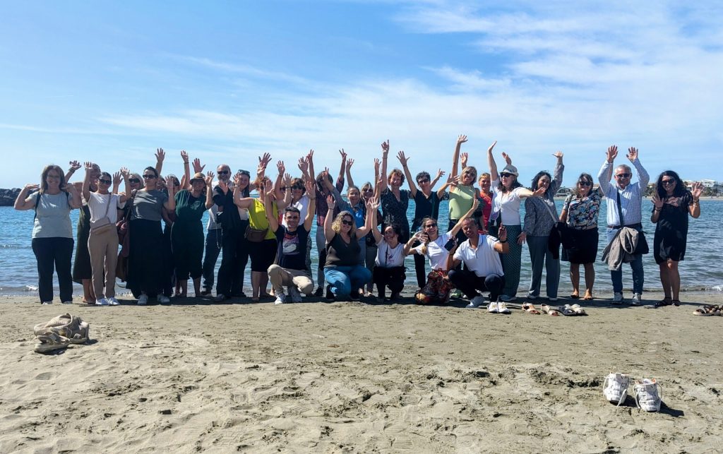 un seminaire ludique de la DREAL avec 40 personnes qui lèvent les bras près de la mer